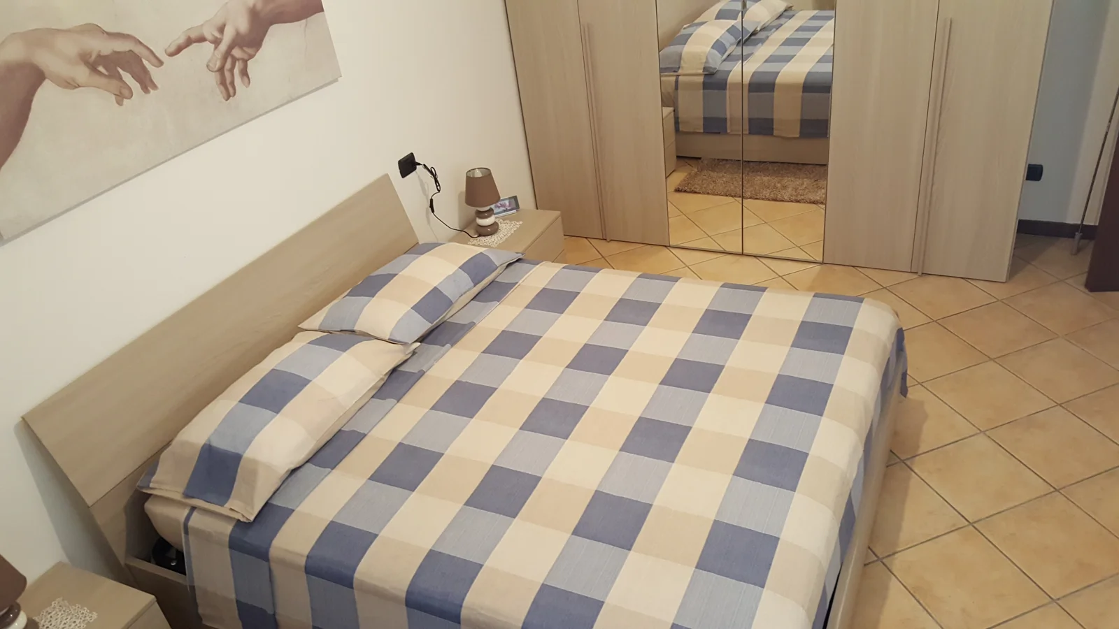 Camera con copriletto a quadri e stampa d'autore